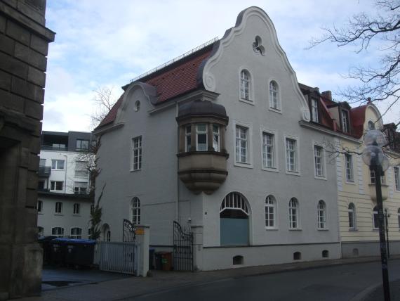 Auf dem Grundstück Münzgasse 5 befanden sich das alte Gemeindehaus samt jüdischer Schule (1840-75), dahinter – am Mühlbach – die erste Mikwe (nach 1760) und die Schächter-Hütte (1867).