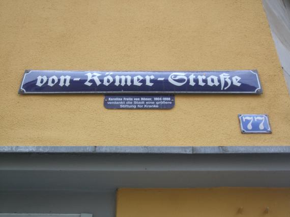 Straßenschild am Eckhaus von-Römer-Straße / Maximilianstraße 77. Karolina von Römer starb 1888, ein Jahr vor Umbenennung der „Judengasse“ zu ihren Ehren.