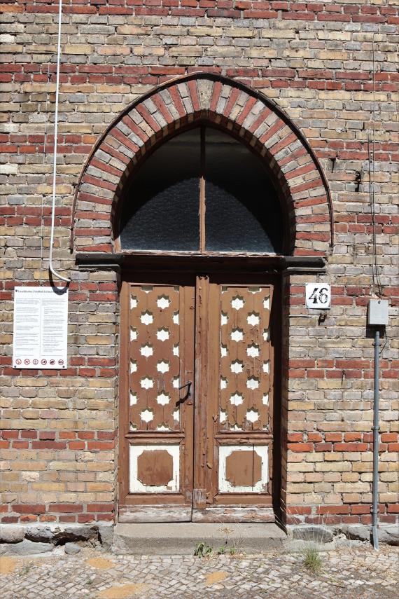 Eingangstür zur Personalwohnung der Trauerhalle (Fermersleber Weg 46). Die Friedhofsordnung (nach 1990) ist in deutscher und russischer Sprache abgefasst.