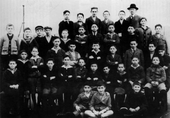 Black and white picture of school class sitting in several rows