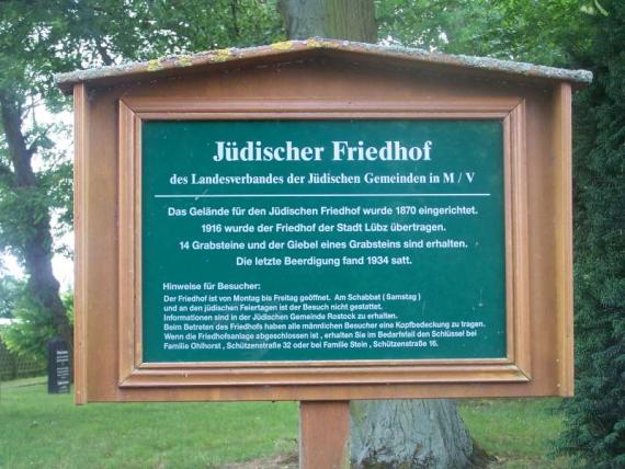 Grüne Infotafel am Friedhof mit Jahresdaten und Zahlen der Grabsteinen