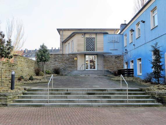 wide staircase leads to flat house, blue house on the right side of the picture