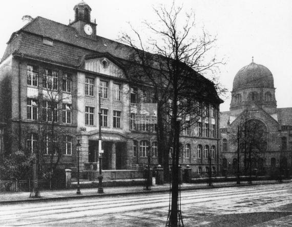 chwarz-weiss-Aufnahme der Talmud Tora-Schule im Vordergrund, im Hintergrund rechts ist die Synagoge zu sehen.