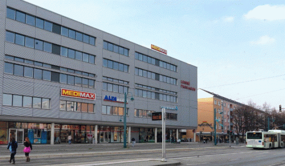 View of a long street. On the left a large shopping center