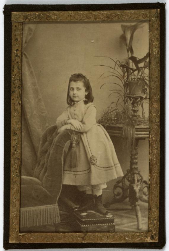 Black and white photo: young girl in an elaborate dress