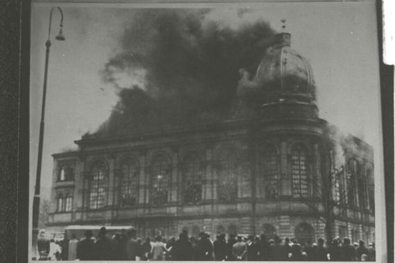 Das Synagogengebäude in Flammen und Rauch am 10. November 1938. Um die Synagoge Menschenmenge