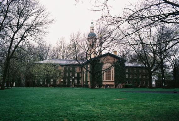 Large, wide house with several floors and windows. In front of the house green lawn