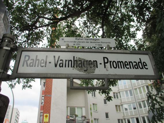 Berliner weißes Straßenschild mit schwarzen Lettern der Rahel-Varnhagen-Promenade