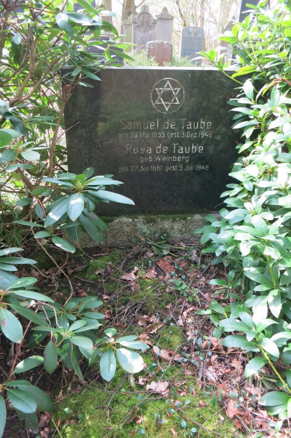 Gravestone made of black smooth granite with the names of the parents and their dates of birth and death, above it a Star of David