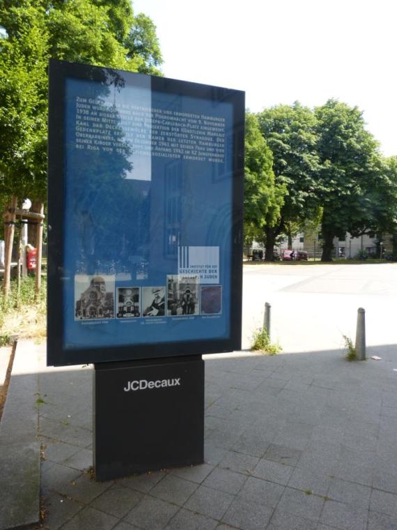 Blaue Gedenktafel in Erinnerung an die jüdische Gemeinde in Hamburg mit schwarz weiß Bildern unten