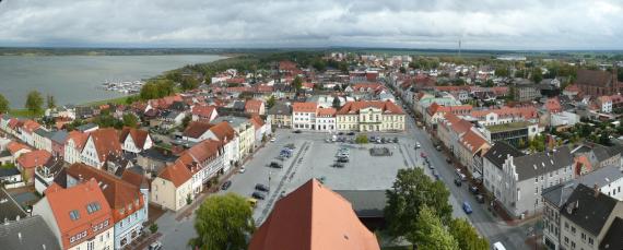 Blick auf Ribnitz vom Turm einer Kirche , links ein Fluss, in der Mitte der Marktplatz