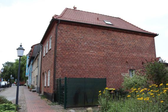 Seitliche Ansicht auf die Backstein-Front eines quadratischen Gebäudes