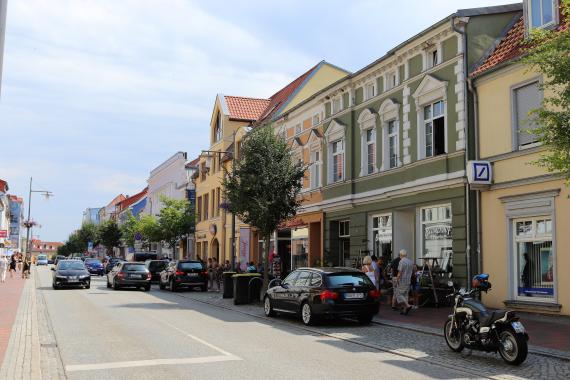 Straße, auf der rechten Seite eine Häuserreihe mit schönen Fassaden