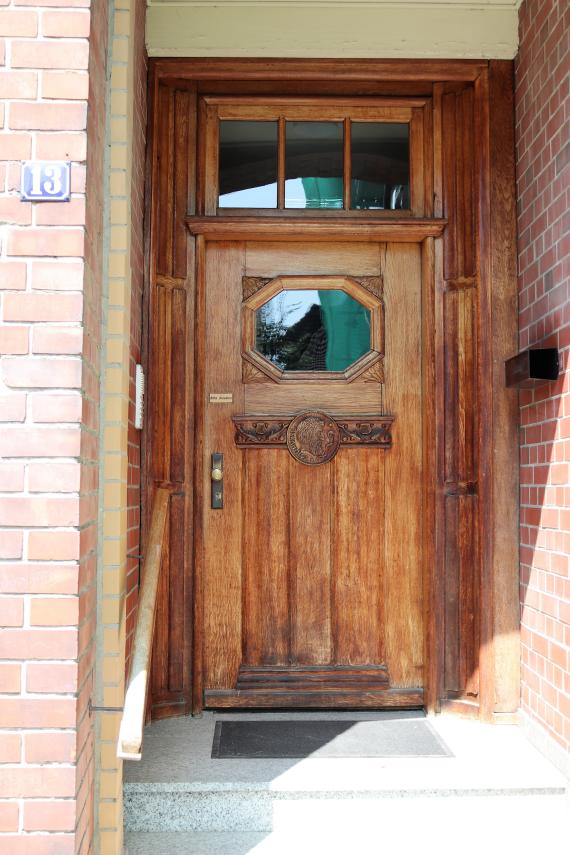 Entrance to a brick house, door made of wood, house number 13