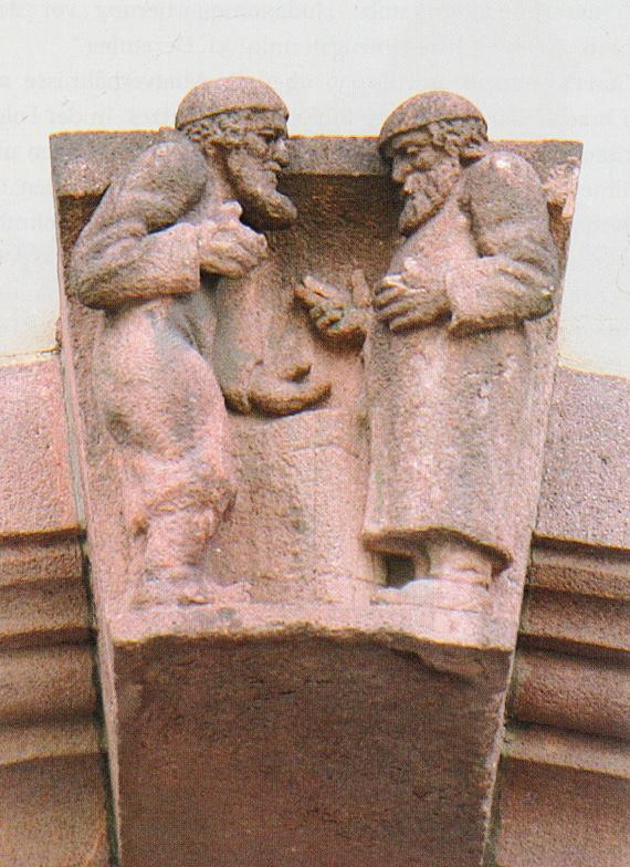 Ein Steinrelief, das zwei jüdische Händler zeigt. Das befindet sich in den Arkaden des Alten Rathauses.