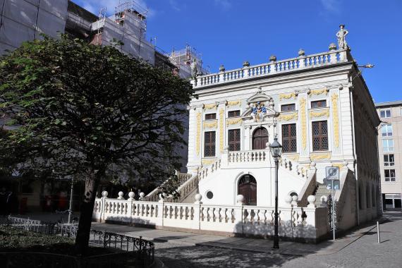 The picture shows a pretty small stately building, which has a staircase on both sides. It was formerly used as a meeting place for merchants.