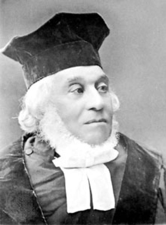 Black and white photo of Nathan Marcus Adler. Adler wears a black hat, a white sash and has white-gray hair and a beard.