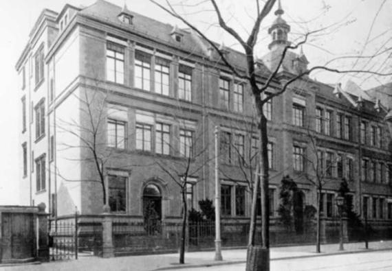Schwarz-Weiß-Foto der Schule; zu sehen ist ein großes Gebäude mit einem kleinen Turm über dem Haupteingang