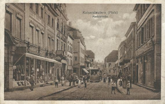 Historische Ansichtskarte Kaiserslautern - Marktstrasse um 1918 mit Geschäften auf beiden Seiten, vielen Passanten auf den Gehwegen und der Straße und einer herannahenden Strassenbahn - linke Seite im Vordergrund - das Herren- und Damenkonfektionsgeschäft Raphael Vendig