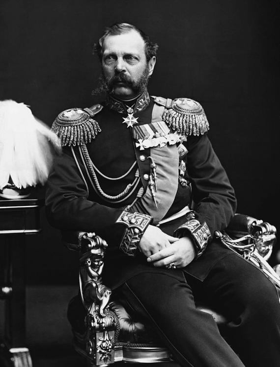 A photo of an elderly man sitting on the throne and wearing a uniform with many awards.