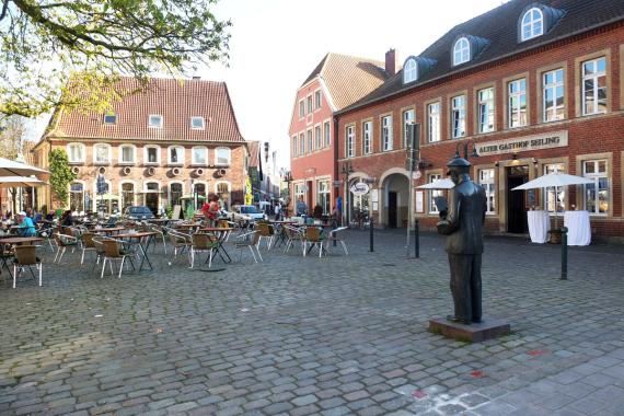 Marktplatz in der Stadt Telgte. Rechts im Bild eine dunkle Statue eines Mannes.