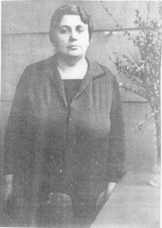 Lina Lewy stands on the balcony parapet of her apartment and looks at the viewer.