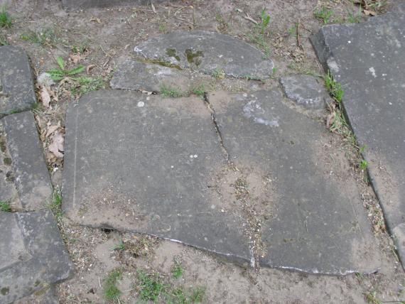 lying broken tombstones with Hebrew writing