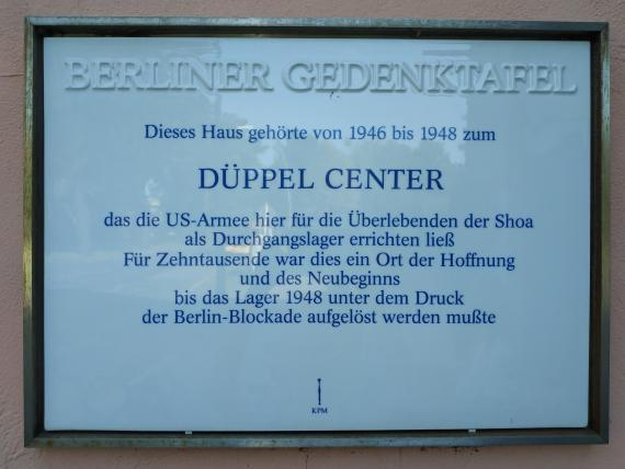 Weiße Gedenktafel mit Informationen zum Düppel-Center.