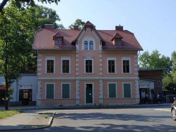 An old pink building stands in the center of the picture.