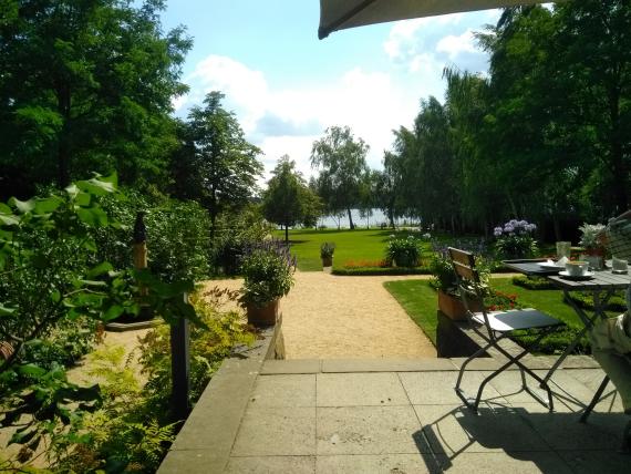 Large lawn with hedges and trees. The garden is open to the Wannsee.