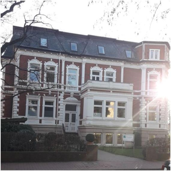 In der Nordstraße 2 steht eine rot-weiß getäfelte Stadtvilla im Barockstil mit einem weißen Vorbau mit Balkon.