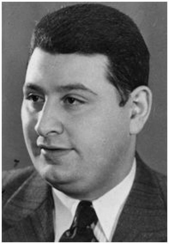 Black and white portrait of Moses Katzenberg not looking at the camera. He has dark hair and eyes and wears a suit with a tie.