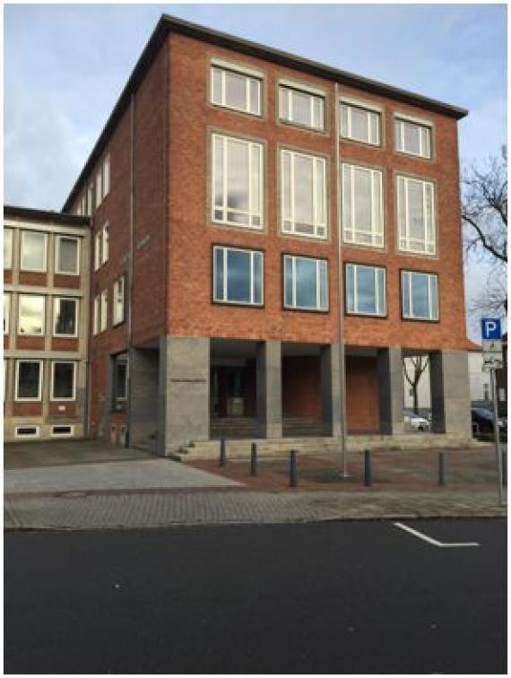 Recent photograph of the building of the Oldenburg Higher Regional Court. It is a square building with large windows and three floors.