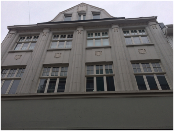 large house with three floors and large windows framed between columns