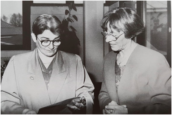 Rabbi Bea Wyler with a folder in her hand. To her left is Sara-Ruth Schumann