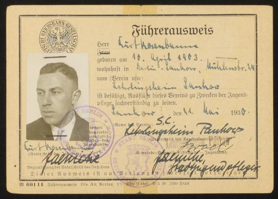 On the left side, of the yellowish faded ID card, you can see a passport photo of a 27 year old man in a suit. On the remaining space is a passport photo of Kurt Rosenbaum. Mr. Rosenenbaum born April 10, 1903, works/lives in the association (Lehrlingsheim Pankow) at Mühlenstraße 24, Berlin-Pankow. The ID card allows him "to lead excursions for the purpose of youth care".  With signatures and stamps of the associated office from Berlin.