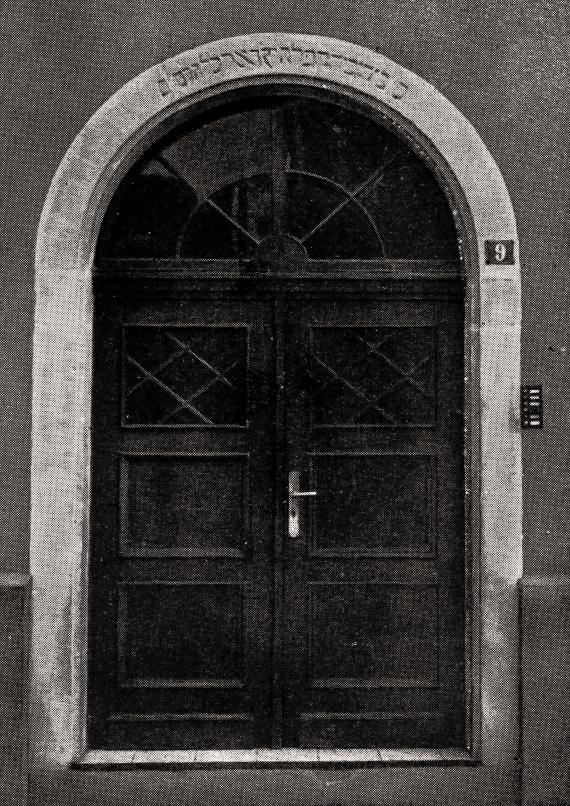 Photograph of the two-winged entrance door. A Hebrew inscription can be seen in the stone door arch.