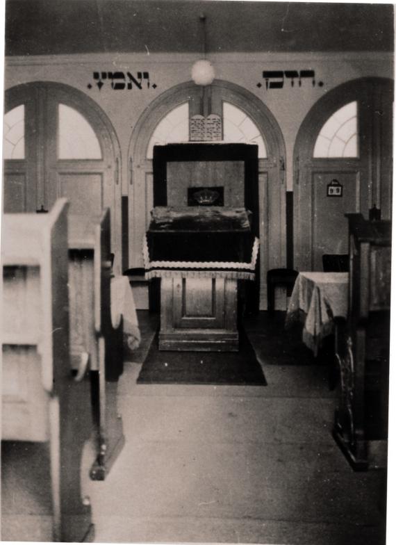 Black and white photograph with view into the presumed prayer room of the synagogue.