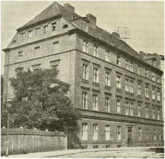 Das Bild zeigt das Jüdisch-Theologische Seminar in Breslau. Das Gebäude ist in Schwarz-Weiß abgebildet und leicht von der Seite zu sehen. Zu erkennen ist ebenfalls die Straße, an der das Gebäude liegt, sowie ein großer Baum, der eine Seitenwand verdeckt.