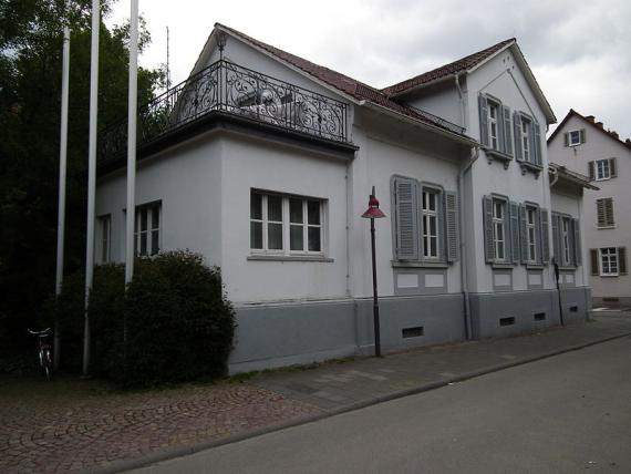 Exterior view of the house with prominent balcony with ornate railing