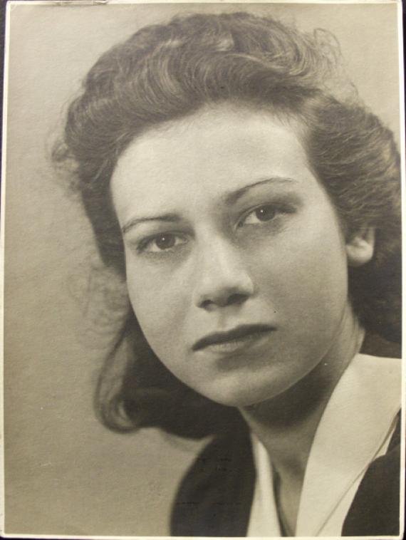 The close-up shows Felice Schragenheim looking directly into the camera with her head slightly tilted. She is wearing a top with a light blouse collar.