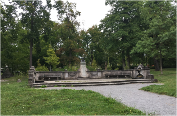 The Brahms memorial, erected in 1899, includes a portrait of the composer on a pedestal. Next to it, in an oval-shaped arrangement, are stone benches.