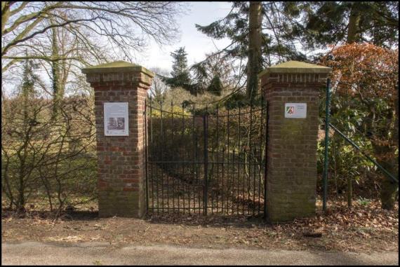 Two large pillars. Between them a lattice gate. Left and right a fence.