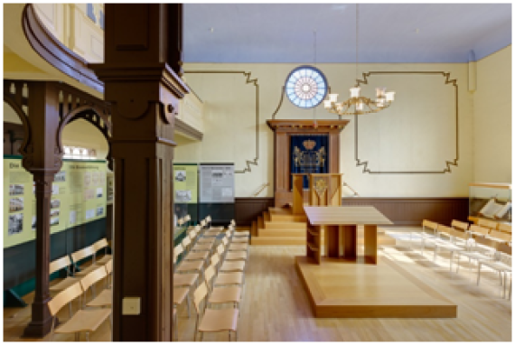 The picture shows the interior of the synagogue, with the Torah shrine in the east and the reading table in the center. Today the synagogue is used as a place for events and commemoration.