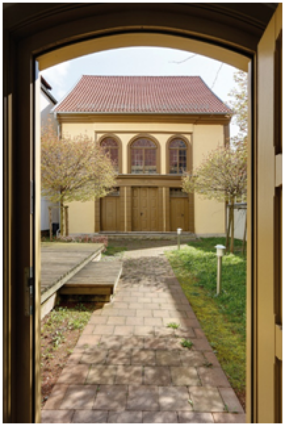 Blick durch die die geöffnete Tür des Vorderhauses auf die Hinterhaus-Synagoge