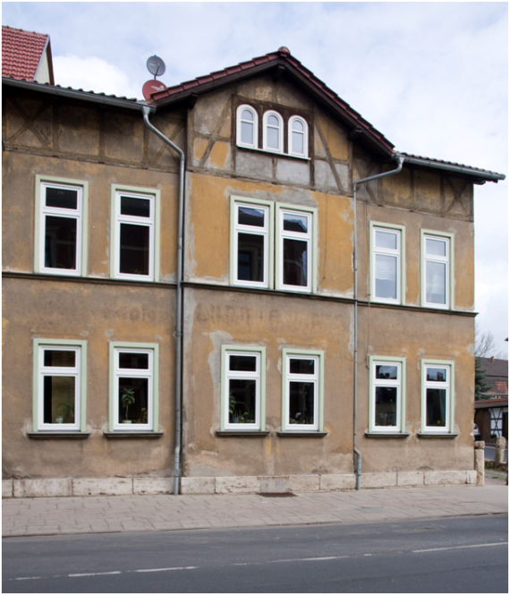 The removed name "Ludwig Maas" in the middle of the house facade can still be seen.