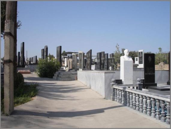 Eine weisse, gerundete Treppe. Sie führt zum Friedhof. Man sieht zahlreiche Grabsteine in verschiedenen Formen.