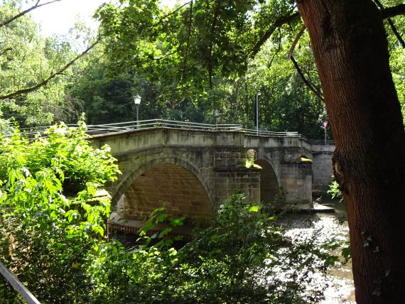 Seitenansicht, alte Steinbrücke, die über einen Fluss führt