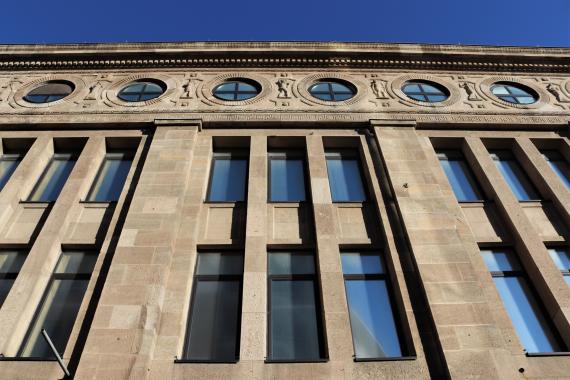 Facade of a large building from the frog perspective. The building has many large windows.