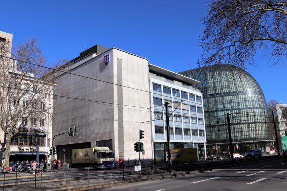 Photo of a large building.in front of it is a street.